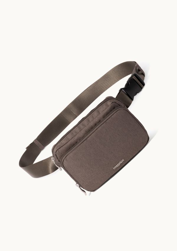 Brown belt bag with adjustable buckle strap and dual zip compartments shown on a light neutral background.